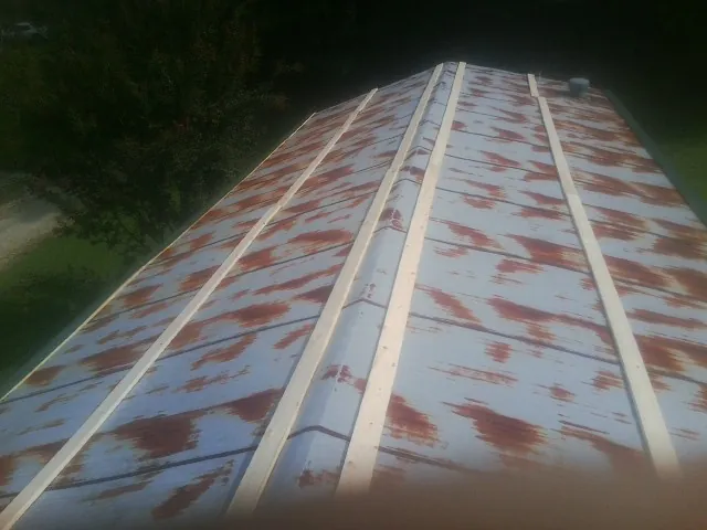 Rusted metal roof panels with new wood purlins before replacement — Storm Damage Roof Repair in Brierfield by Roofing Brothers