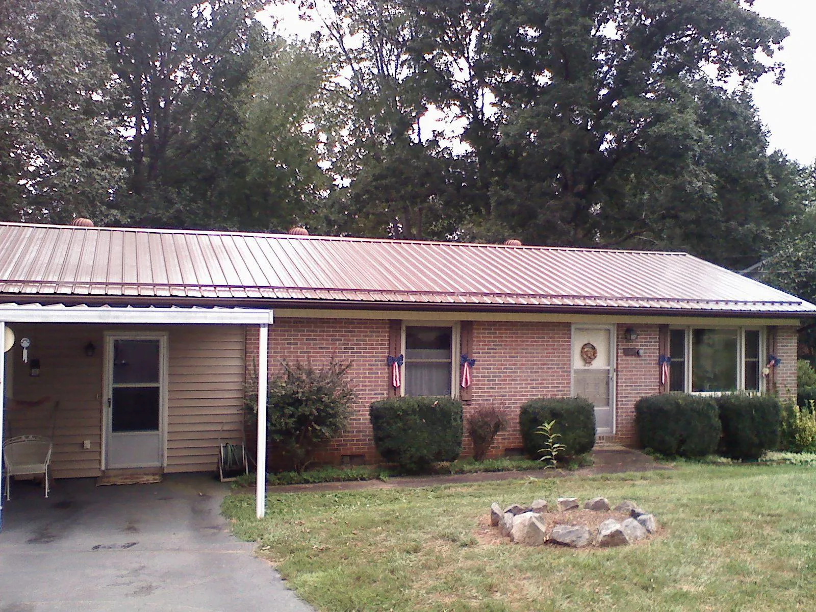 Bronze metal roof and carport on a brick ranch home — Roof Repair work by our crew in Brierfield